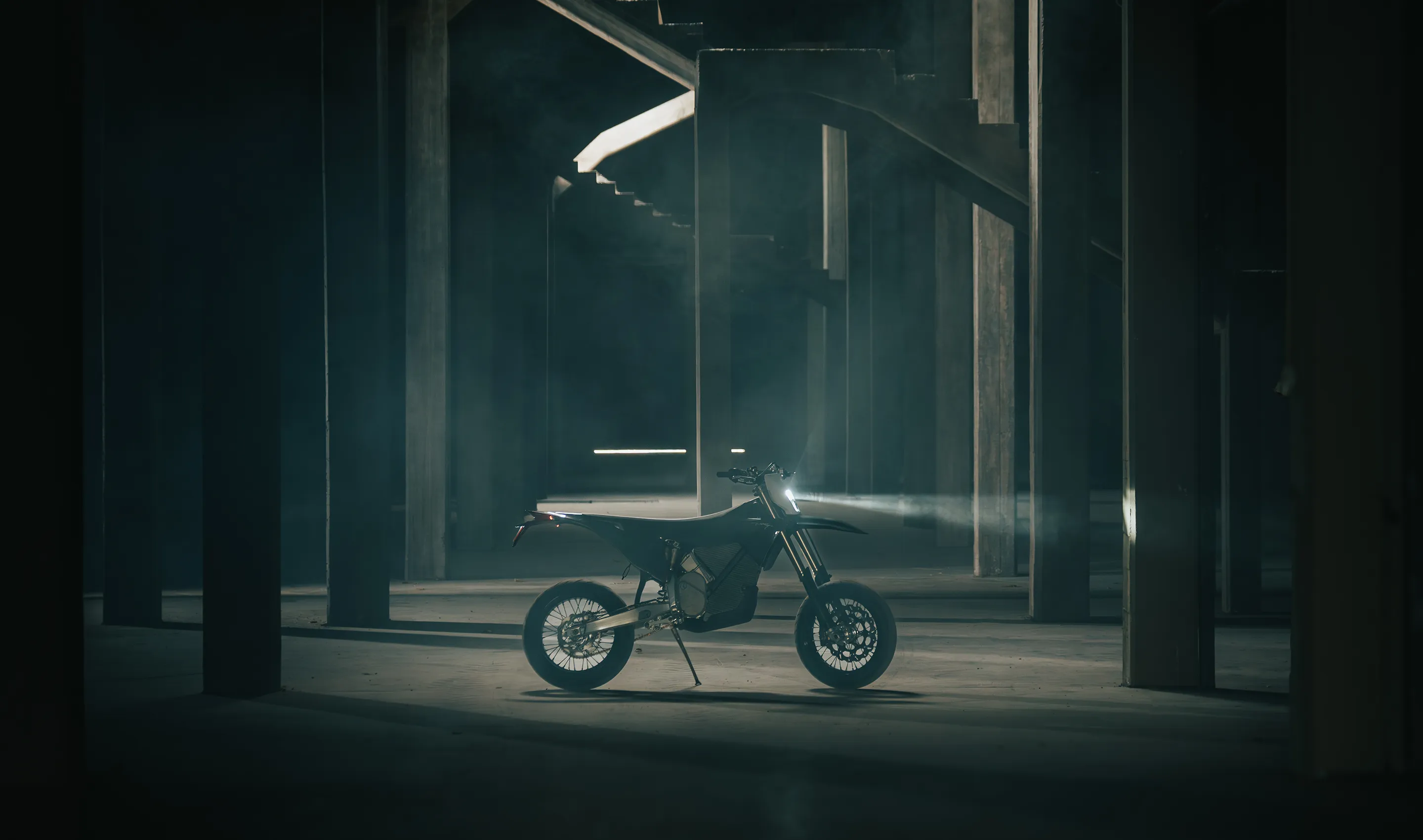 Front 3/4 view of Stark VARG SM showing aggressive supermoto stance, 17-inch wheels, and road-legal lighting